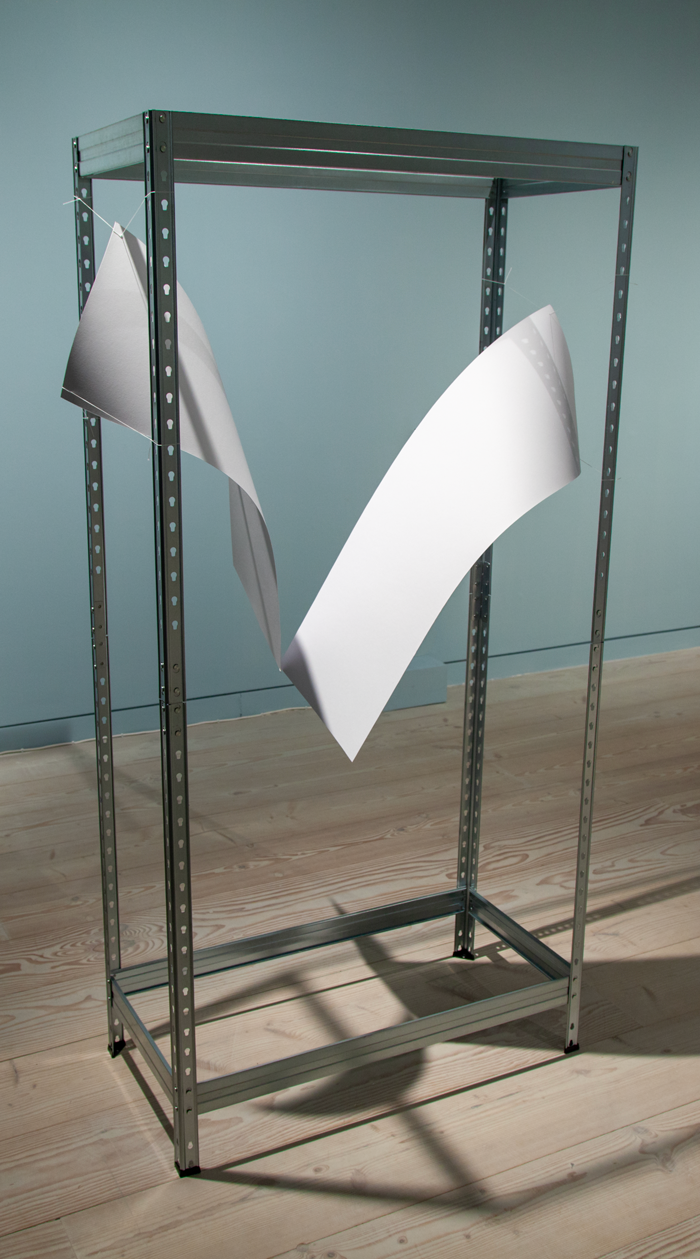 Paper sculpture in a metal frame. two large pieces of card suspended by binding thread from an industrial metal frame, in a blue walled art gallery with a wooden floor